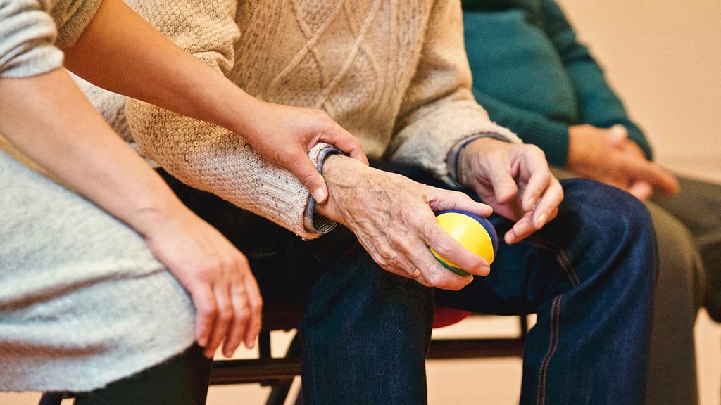 Symbolbild: Eine Pflegerin hält die Hand eines älteren Patienten, Link zur Seite "Anerkennung ausländischer Berufsabschlüsse in Gesundheitsfach- und Sozialberufen"