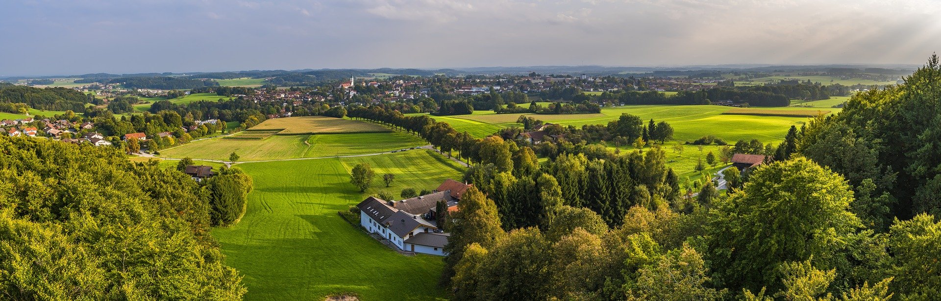Symbolbild: Luftaufnahme einer Thüringer Landschaft im Grünen mit einer kleinen Kommune mittig, Link zur Seite "Förderung der kommunalen Zusammenarbeit"