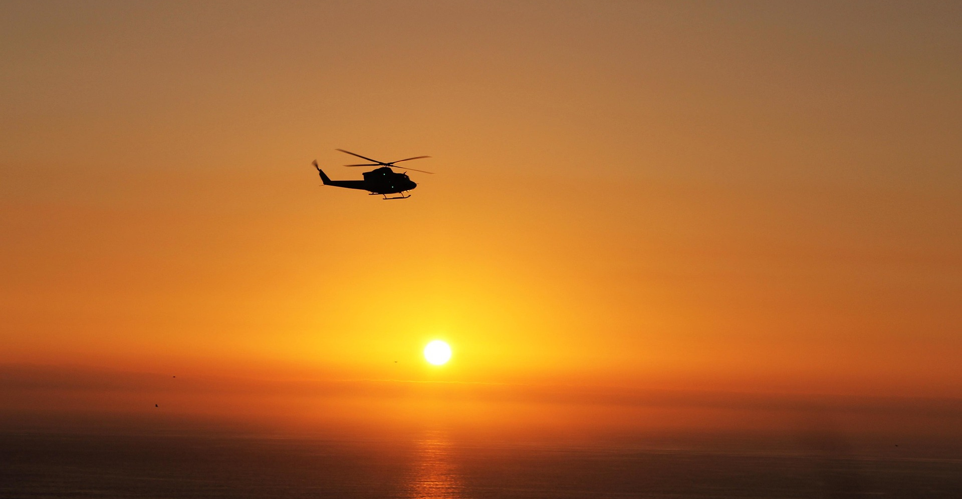 Hubschrauber fliegt im Sonnenuntergang